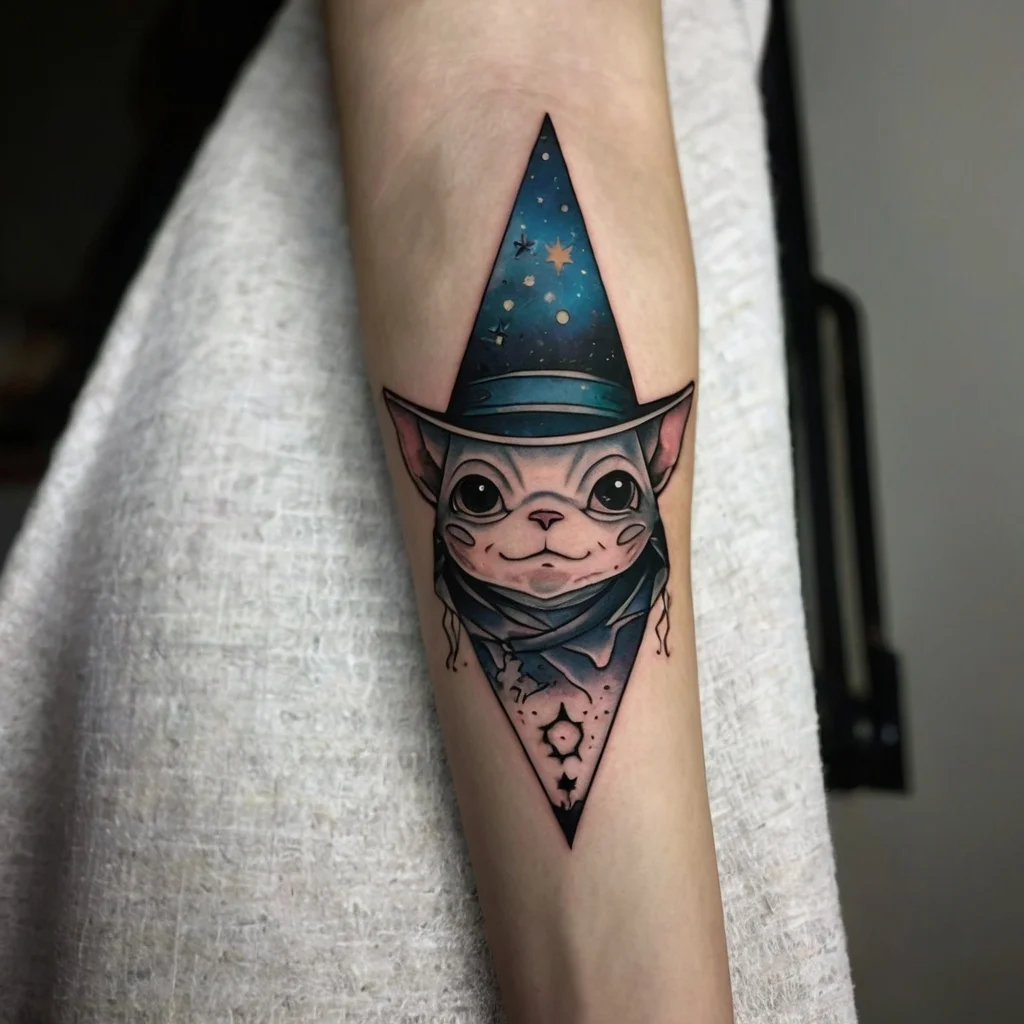 Tattoo of a sphynx cat in a pointed wizard hat, with cosmic elements and swirling galaxy colors, in a geometric style.