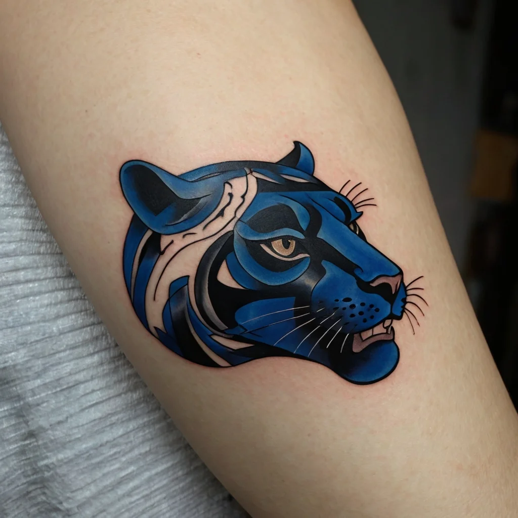 Stylized blue and black tiger head tattoo with bold lines and geometric shapes, showcasing fierce eyes and intricate shading.