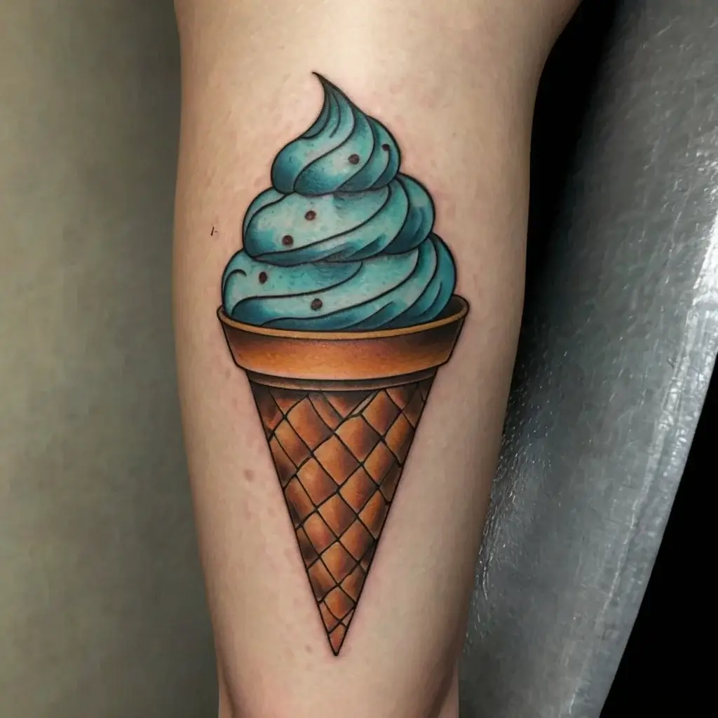 Tattoo of a realistic blue ice cream cone with swirl detail, nestled in a textured brown waffle cone, on leg skin.