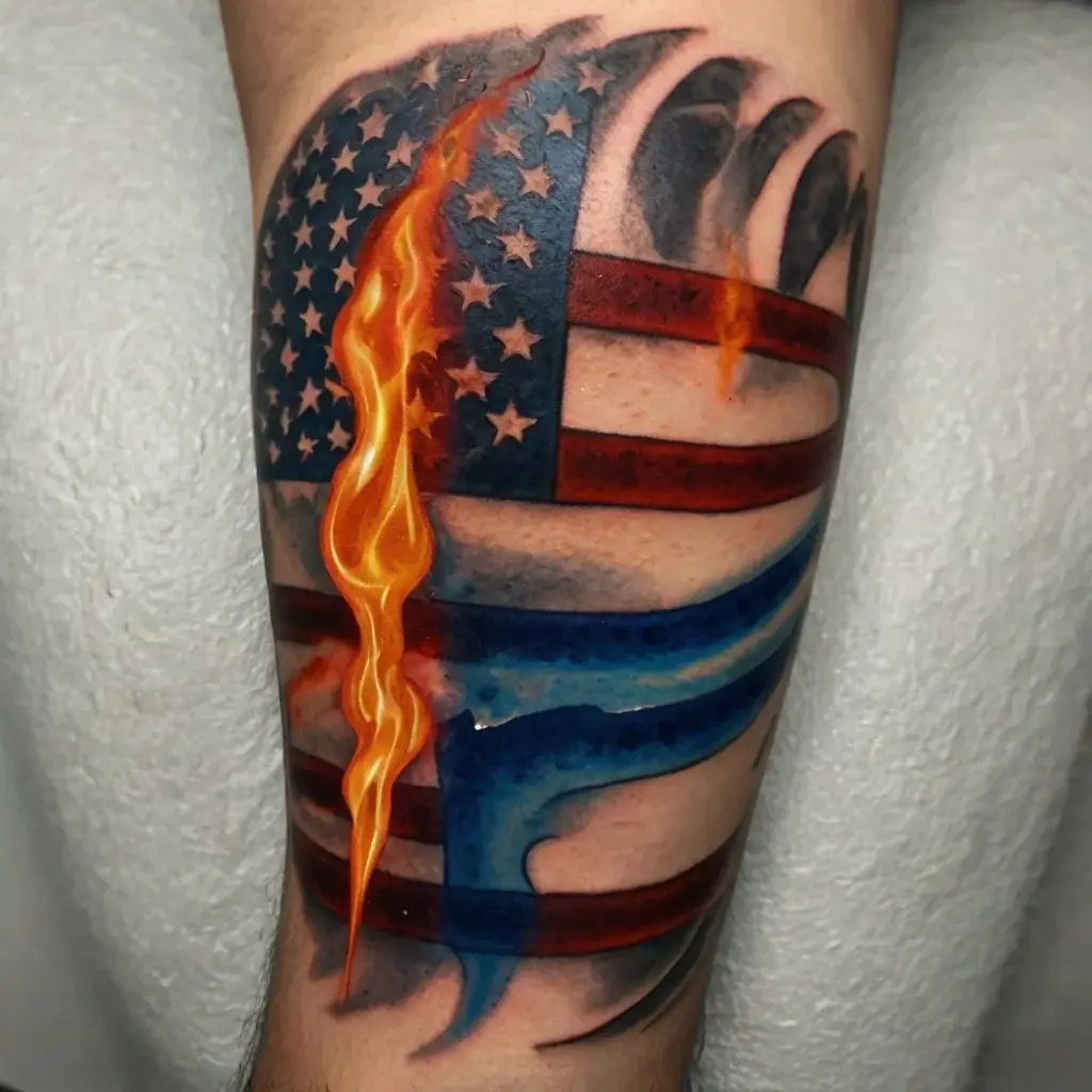 Tattoo of American flag with realistic flames and shark motif blending in, symbolizing strength and resilience.