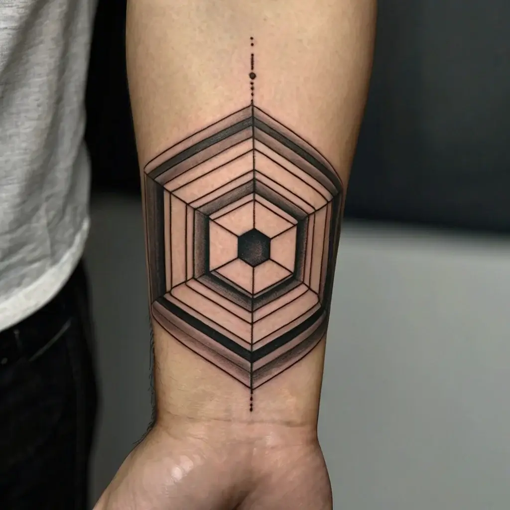 Geometric tattoo on forearm, featuring layered hexagons with shaded lines, forming a 3D effect, with a central dot line.